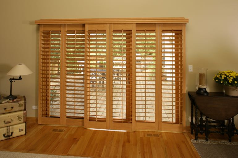 Wood shutters on sliding door connecting to full porch.